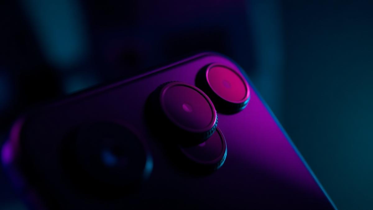 Smartphone camera lens closeup with dramatic lighting showing multiple camera sensors